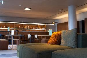 een lobby met een bank en een bar met krukken bij Templo Hotel & SPA in Braga