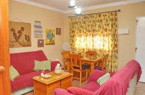 a living room with a red couch and a table at Casa familiar Palmar in El Palmar
