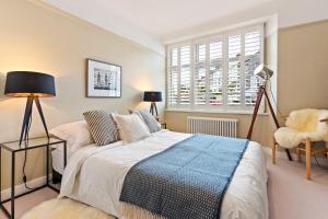 a bedroom with a bed and a chair and a window at Waterside cottage - log burner - 10 mins to Falmouth in Flushing