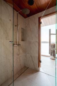 a bathroom with a shower with a glass door at Stay North - Joiku - Midnight Sun in Äkäslompolo +14 photos