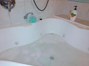 a white bath tub with a faucet in a bathroom at Cheerful Bush House in Hepburn Springs