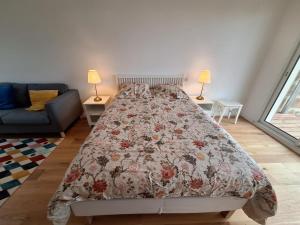 Un dormitorio con una cama con una colcha floral. en Studio 2 rénové balcon garage, en Burdeos