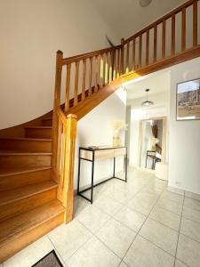 a staircase in a living room with a table at Maison de vacances tout confort - 300m des plages in Larmor-Plage
