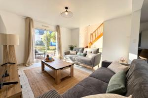 a living room with a couch and a table at Maison de vacances tout confort - 300m des plages in Larmor-Plage