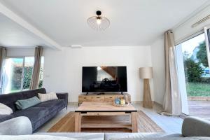 a living room with a couch and a coffee table at Maison de vacances tout confort - 300m des plages in Larmor-Plage +36 photos