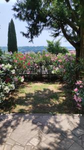 a garden with pink and white flowers and a tree at Cozy Apartments Portorož in Portorož