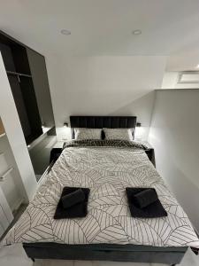 a bedroom with a bed with two black pillows on it at MA-LU apartment Osijek in Osijek