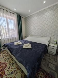 a bedroom with a bed with two towels on it at Guest house Nuri in Karakol