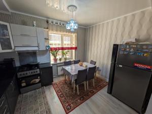 a kitchen with a table with chairs and a refrigerator at Guest house Nuri in Karakol +27 photos