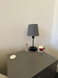 a table with a lamp and a cup on it at City Centre flat with Balcony in Kent
