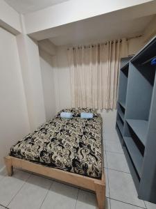 ein kleines Schlafzimmer mit einem Bett vor einem Fenster in der Unterkunft Camia transient in Baguio City