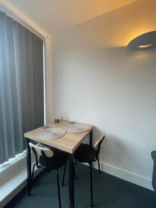 a table and chairs in a room with a window at City Centre flat with Balcony in Kent