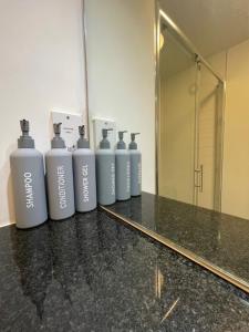 a row of bottles ofodorizers on a counter in front of a mirror at City Centre flat with Balcony in Kent +1 photo