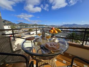 a glass table with food on top of a balcony at Apartamento Joandani by Feseal - Puerto Pollensa in Port de Pollensa