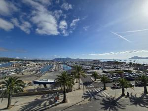 a parking lot with palm trees and a harbor at Apartamento Joandani by Feseal - Puerto Pollensa in Port de Pollensa