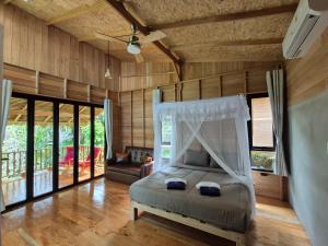 a bedroom with a bed in a room with wooden walls at Nature Hill in Ko Mook