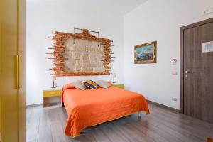 Un dormitorio con una cama con una manta naranja. en il Sogno di Partenope By Rosa Loporchio, en Nápoles