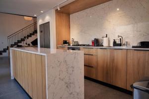 a kitchen with wooden cabinets and a marble counter top at רום אמירים - מתחם אירוח מהמם עם בריכות מחוממות מול נוף עוצר נשימה in Amirim +29 photos
