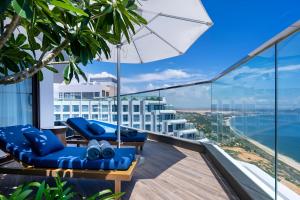 a balcony with blue chairs and an umbrella at Mandala Twilight Haven 5 Star in Phan Thiet