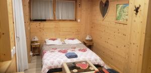 a bedroom with a bed in a wooden cabin at Appartement 2 pièces cuisine Les Hermines in Saint-Nicolas-la-Chapelle