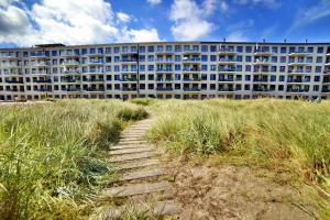 a building on the beach with a path in front at Ferienwohnung Penthouse 17 im Haus Düne 7 Prora in Binz