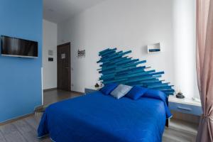 Un dormitorio con una cama azul y una pared grande en il Sogno di Partenope By Rosa Loporchio, en Nápoles