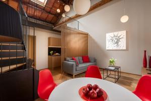 a living room with a table and red chairs at Rambaldi Apartments Casa nr 7 in Bardolino
