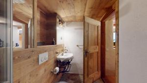 a bathroom with a toilet and a sink and a mirror at Chesa Güglia Silvaplana in Silvaplana +5 photos