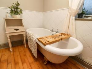 y baño con bañera y bandeja de madera. en Woodside Cottage, en Skipton 15 fotos más