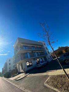 Un edificio blanco con un coche aparcado delante. en EmmasHome, en Sibiu 26 fotos más