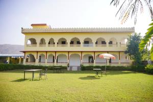 a large building with tables and chairs in a yard at The Great Meva Palace Pushkar in Pushkar