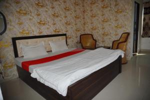 um quarto com uma cama grande com duas cadeiras em The Great Meva Palace Pushkar em Pushkar