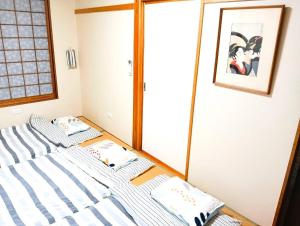 two beds in a room with a mirror at 鶴の宿 那覇-国際通りまで950mの便利な立地-1棟貸切 in Naha