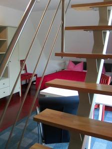 Una habitación con escaleras con una cama roja dentro. en Ostsee, en Diedrichshagen