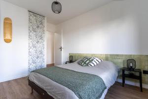 een slaapkamer met een groot bed en een raam bij Abondance 16 in Cergy