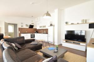 un soggiorno con divano in pelle marrone e TV di Ferienwohnung Strandnest in der Villa Gudrun Binz a Binz