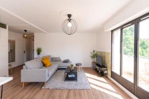 een woonkamer met een bank en een tafel bij Abondance 16 in Cergy