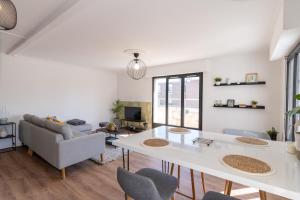 een woonkamer met een witte tafel en een bank bij Abondance 16 in Cergy