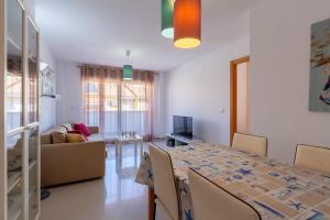 Un comedor y una sala de estar con mesa y sillas. en Apartamento en El Campello, España, en El Campello