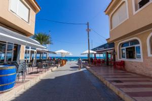 una persona caminando por una acera cerca de la playa en Apartamento en El Campello, España, en El Campello