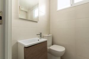 a white bathroom with a toilet and a sink at Ático a pie de playa para relax y teletrabajo in Santa Pola +36 photos