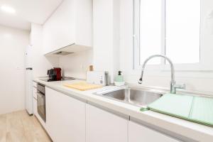 a kitchen with white cabinets and a sink at Balcón Mediterráneo - Desconexión a pie de playa in Santa Pola +38 photos