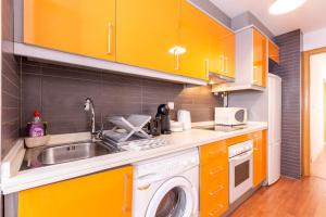cocina con armarios amarillos y lavadora en Apartamento Cerca del Mar y aeropuerto, en Alicante 22 fotos más