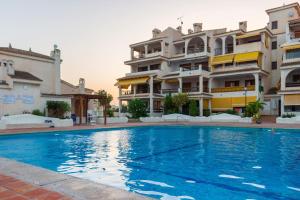 a swimming pool in front of a building at Varadero - Bungallow a pie de la playa in Santa Pola
