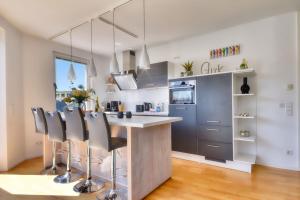 una cucina con bancone, sedie e isola cucina di Ferienwohnung Strandgold im Haus Seeblick Binz a Binz