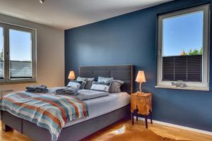 una camera blu con un letto e due finestre di Ferienwohnung Strandgold im Haus Seeblick Binz a Binz