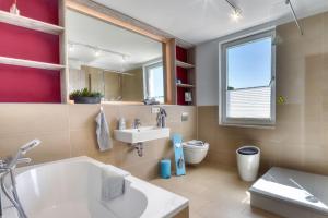un bagno con vasca, lavandino e WC di Ferienwohnung Strandgold im Haus Seeblick Binz a Binz Altre 15 foto