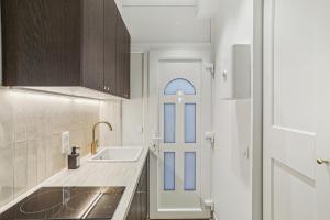 a white kitchen with a sink and a door at Lavie Maison Hot Tub and AC Near Arc de Triomphe in Paris +35 photos