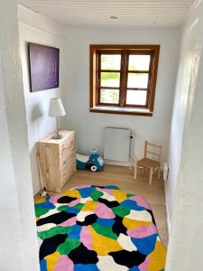 une pièce avec un tapis coloré sur le sol dans l'établissement Charming Cottage In The Best Hc Andersen Style, à Frørup