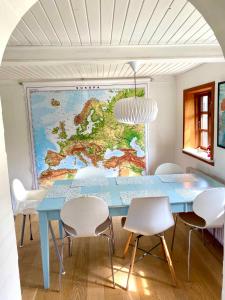 une salle à manger avec une table bleue et des chaises blanches dans l'établissement Charming Cottage In The Best Hc Andersen Style, à Frørup